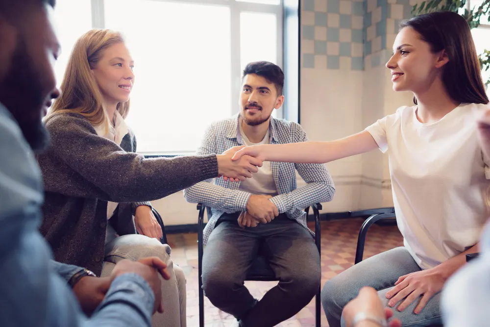 Mujeres estrechando la mano en coaching de equipos